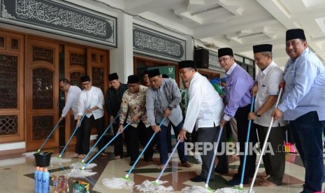 Wakil Ketua Dewan Masjid Indonesia Syafruddin saat mengepel masjid pada acara bersih-bersih masjid di Masjid Al-Mabrur, Asrama Haji Pondok Gede, Jakarta, Ahad (28/4).