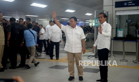 Presiden Joko Widodo dan Ketua Umum Partai Gerindra Prabowo Subianto melambaikan tangannya saat tiba di Stasiun MRT Lebak Bulus, Jakarta, Sabtu (13/7).