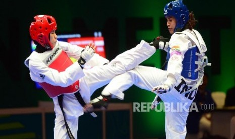 Atlet Kyorugi Taekwondo Indonesia Mariska Halinda (merah) melakukan serangan kepada lawannya Latika Bhandari (biru) dari India pada babak perempat final pertandingan Taekwondo kelas kyorugi under 53 kg, pada event Invitation Torunament Asian Games 18 di Jakarta, Sabtu (10/2).