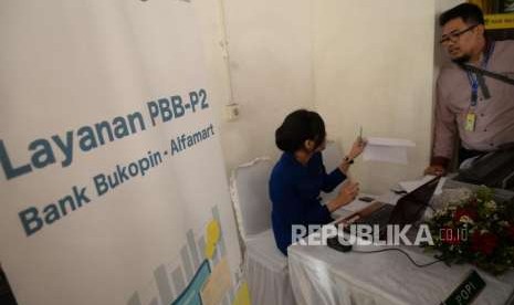 Layanan Pembayaran PBB. Petugas Bank Bukopin melayani pembayaran Pajak Bumi dan Bangunan untuk Perdesaan dan Perkotaan (PBB P2) saat peluncuran di Jakarta, Rabu (12/9).