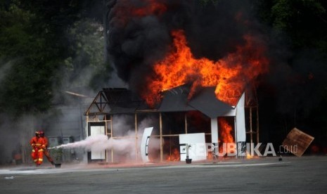 Petugas pemadam kebakaran memadamkan api saat simulasi penanganan aksi terorisme di JIExpo Kemayoran, Jakarta, Rabu (25/7).