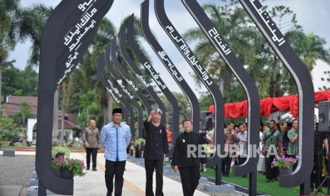 Presiden Joko Widodo (tengah) berjalan didampingi Gubernur Jawa Barat Ridwan Kamil (kiri) dan Plt Bupati Cianjur Herman Suherman (kanan) saat meninjau Alun-alun kota Cianjur, Jawa barat, Jumat (8/2).