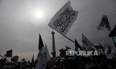 Sejumlah massa mengibarkan bendera tauhid saat mengikuti reuni aksi 212 di Lapangan Monumen Nasional, Jakarta, Ahad, (2/12).