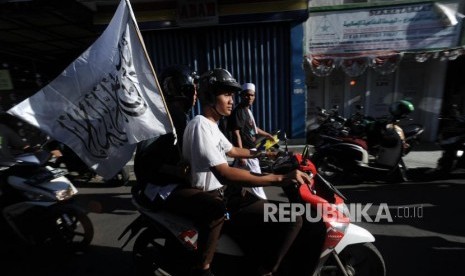 Laskar FPI  melintas  membawa bendera di hadapan Markas DPP FPI di Petamburan, Jakarta, Rabu (21/1).