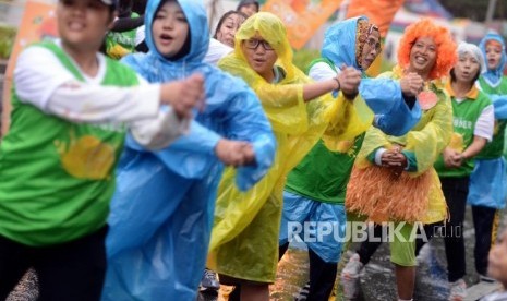 Olahraga Saat Hujan. Warga berolahraga menggunakan jas hujan pada hari bebas kendaraan bermotor di Jalan Jenderal Sudirman, Senayan, Jakarta.