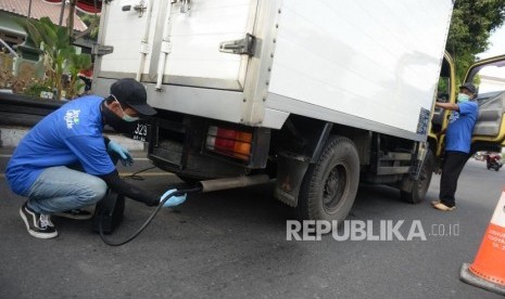 Petugas mengukur emisi kendaraan saat uji emisi.