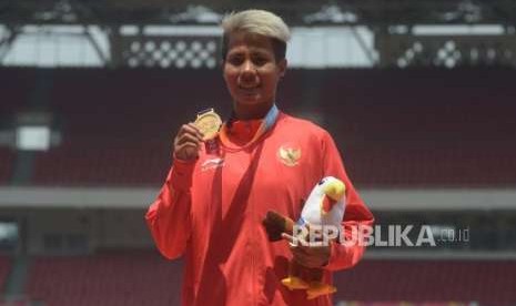 Atlet Indonesia  Rika Oktavia  berfoto usai menerima medali emas para-atletik putri T20 nomor lompat jauh Asian Para Games di Stadion Utama Gelora Bungkarno, Jakarta, Senin (8/10).