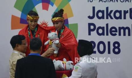 Ketua Umum Pengurus Besar Ikatan Pencak Silat Seluruh Indonesia Prabowo Subianto memberikan medali kepada Pesilat Indonesia Ayu Sidan Wilantari dan Ni Made Dwiyanti usai memenangkan pertandingan cabang olahraga silat Asian Games 2018 kategori ganda putri di Padepokan Pencak Silat TMII, Jakarta, Rabu (29/8).