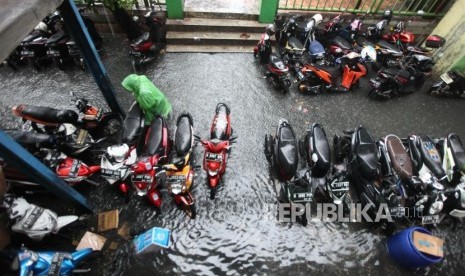 Warga melintasi genangan air di Pasar Blok G Tanah Abang, Jakarta, Senin (11/12).