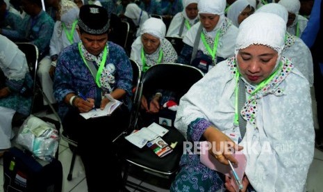 Sejumlah calon jamaah haji melihat lembaran kertas yang terdapat pada paspor di Asrama Haji Bekasi, Bekasi, Jawa Barat, Rabu (25/7).