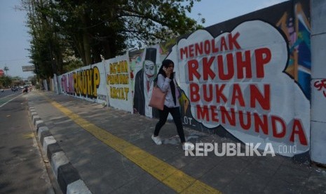 Warga melintas di area mural Tolak RUU RKUHP di Rawamangun, Jakarta Timur, Senin (30/9/2019).