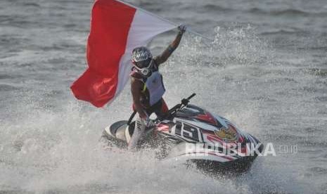 Atlet jetski Indonesia Aqsa Sutan Aswar membawa bendera merah putih seusai berhasil menjadi juara dalam cabang jetski nomor Endurance Runabout Asian Games 2018 di Ancol, Jakarta, Ahad (26/8).