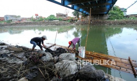 Dua penduduk berusaha mengangkat sampah Sungai Citraum, di Sektor enam program Citarum Harum Kodam III/Siliwangi, Kecamatan Bojongsoang, Kabupaten Bandung, Selasa (24/4).