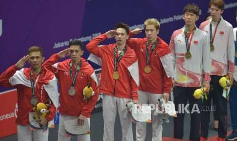 Pebulu tangkis Indonesia Marcus Fernaldi Gideon/Kevin Sanjaya Sukamuljo memberikan hormat kepada bendera merah putih dalam prosesi penyerahan medali cabang bulu tangkis nomor ganda putra Asian Games 2018 di Istora Senayan, Jakarta, Selasa (28/9).