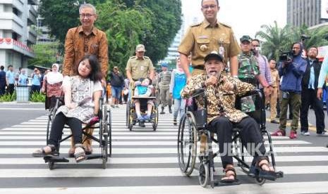 Gubernur DKI Jakarta Anies baswedan bersama Direktur Utama PT Transportasi Jakarta Budi Kaliwono mengantarkan penyandang disabilitas menyeberangi pelican crossing di Jalan MH Thamrin, Jakarta Pusat, Selasa (4/9).