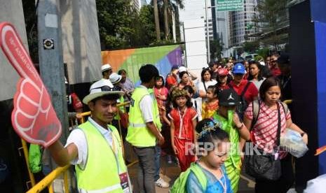 Relawan memberikan petunjuk arah jalan kepada pengunjung di kawasan GBK, Jakarta, Sabtu (18/8).