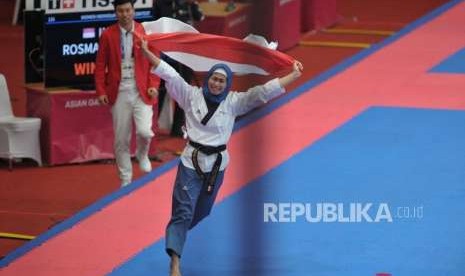 Atlet taekwondo putri Indonesia Defia Rosmaniar melakukan selebrasi seusai meraih medali emas dalam cabang taekwondo nomor poomsae Asian Games 2018 di Jakarta Convention Center, Senayan, Jakarta, Ahad (19/8).