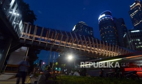 Warga memotret jembatan penyeberangan orang (JPO) Gelora Bung Karno di Jalan Jenderal Sudirman, Jakarta, Rabu (27/2).