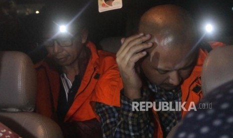 Kalapas Sukamiskin Wahid Husen (kiri) bersama Staf Lapas Hendri Saputra (kanan) memakai rompi tahanan didalam mobil seusai menjalani pemeriksaan di Gedung KPK, Jakarta, Sabtu (21/7).