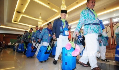 Sejumlah calon jamaah haji mengantre untuk melakukan pemeriksaan pasport sebelum berangkat ke Bandara Soekarno Hatta di Asrama Haji Pondok Gede, Jakarta, Rabu (18/7).