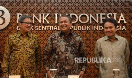 Gubernur Bank Indonesia (BI) Perry Warjiyo (tengah) didampingi Deputi Gubernur Mirza Adityaswara (kanan) dan Erwin Rijanto (kiri) bersiap memberikan keterangan pers hasil Rapat Dewan Gubernur di kantor pusat BI, Jakarta, Jumat (29/6).