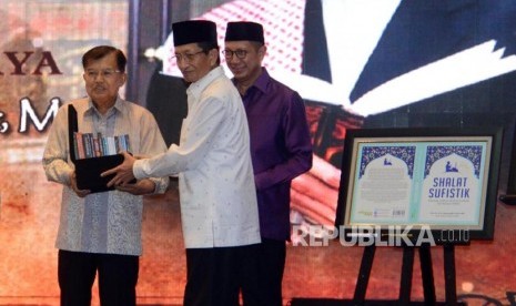 Imam Besar Masjid Istiqlal Nasaruddin Umar memberikan buku karanganya kepada Wakil Presiden Jusuf Kalla pada acara tasyakuran 60 tahun dan peluncuran buku di Jakarta, Ahad (23/6).