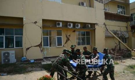 Anggota TNI membawa korban gempa bumi menuju rumah sakit lapangan di Rumah Saki Tanjung, Lombok Utara, Nusa Tenggara Barat, Rabu (8/8).