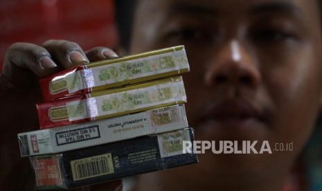 Pedagang menunjukan bungkus rokok bercukai di pasar Minggu, Jakarta, Ahad (15/9).