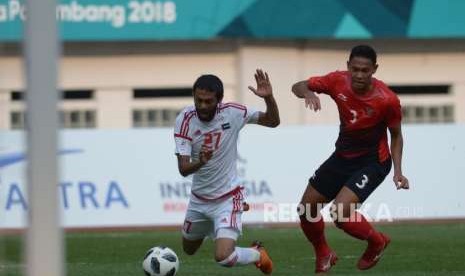 Pesepakbola Indonesia Ricky Fajrin Saputra berebut bola dengan pesepakbola Uni Emirate Arab Zayed Alamaeri dalam pertandingan cabang sepakbola Asian Games 2018 di Stadion Wibawa Mukti, Cikarang, Jawa Barat, Jumat (24/8).