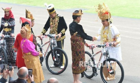 Presiden Joko Widodo memberikan hadiah sepeda kepada peserta upacara dengan kostum daerah terbaik seusai upacara peringatan detik-detik proklamasi kemerdekaan RI di Istana Merdeka, Jakarta, Sabtu (17/8).