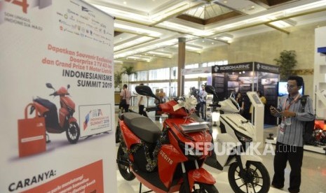 Pengunjung melihat motor listrik pada pameran Indonesianisme Summit 2019 di Jakarta Convention Center, Jakarta, Selasa (13/8).