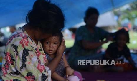 Ulan (1) salah satu anak yang selamat dari bencana gempa bumi saat berada di tenda pengungsian di Lapangan Kantor Walikota Palu, Sulawesi Tengah, Senin (1/10).