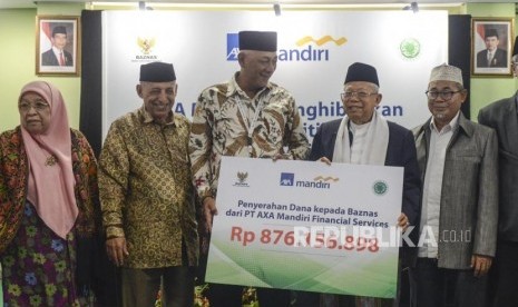 Director of Sales AXA Mandiri Henky Oktavianus (ketiga kiri) bersama Ketua Umum MUI KH Ma'ruf Amin (kedua kanan) dan Komisioner Baznas Ahmad Satori (kanan) saat penyerahan dana surplus underwriting secara simbolis di Gedung MUI, Jakarta, Selasa (24/9).