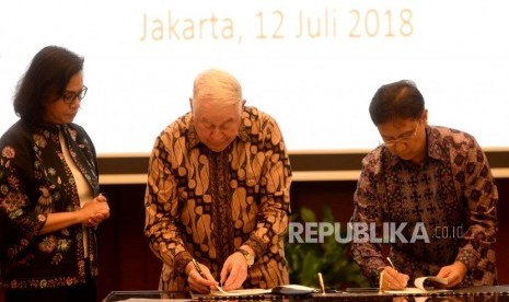 PT Inalum President Director Budi Gunadi Sadikin and CEO Freeport-McMoran Inc Richard Adkerson sign  the divestment agreement of PT Freeport Indonesia shares, witnessed by Minister of Finance Srri Mulyani (from the right) at the Ministry of Finance, Jakarta, Thursday (July 12). 