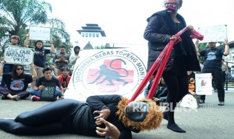 Aksi teaterikal yang menggembarkan penderitaan monyet yang dipekerjakan saat aksi Air Mata Topeng Monyet yang digelar Jakarta Animal Aid Network (JAAN) dalam rangka Peringatan Hari Primata Nasional, di depan Gedung Sate, Kota Bandung, Selasa (30/1).