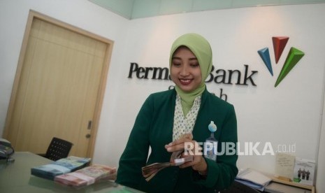 Petugas melayani transaksi nasabah di kantor layanan Permata Bank