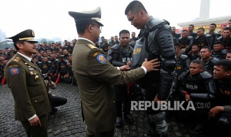 Gubernur DKI Jakarta Anies Baswedan meninjau personil Satpol PP saat menghadiri Apel besar dalam rangka memperingati HUT Satpol PP ke-68 di Lapangan Monas, Jakarta, Kamis (26/4).