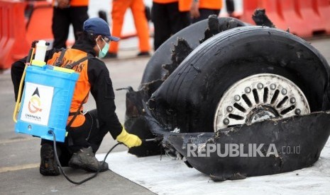 Petugas menyemprotkan disinfektan ke puing-puing pesawat Lion Air JT-610 di Tanjung Priok, Jakarta, Senin (5/11).