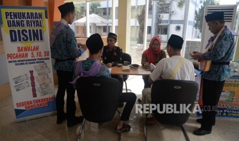 Petugas melayani penukaran mata uang Riyal untuk calon jamaah haji di Asrama Haji Pondok Gede, Jakarta, Jumat (19/7).