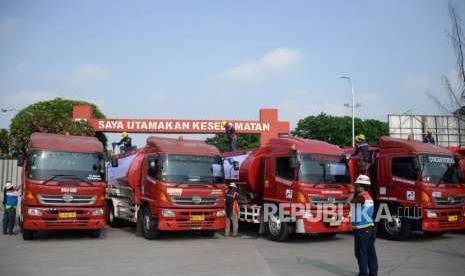 Awak Mobil Tangki (AMT) melakukan persiapan sebelum berangkat untuk mendistribusikan BBM dan Avtur menuju ke Sulawesi, di Terminal Bahan Bakar Minyak (TBBM) Plumpang, Jakarta, Selasa (2/10).