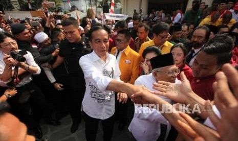 Calon presiden Joko Widodo (kiri) didampingi calon wakil presiden Ma'ruf Amin (kanan) bersalaman dengan para relawan seusai deklarasi di Gedung Joang, Jakarta, Jumat (10/8).