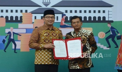 Gubernur Jawa Barat Ridwan Kamil dan Kepala BPN Provinsi Jawa Barat Yusuf Purnama (kanan) memperlihatkan dokumen kerja sama saat acara Penandatanganan Dokumen Kerja Sama Optimalisasi Pendapatan Daerah dan Penertiban Barang Milik Daerah Se-Jawa Barat Tahun 2019 bersama Pemprov Jawa Barat, KPK dan Bank BJB, di Aula Barat, Gedung Sate, Kota Bandung, Senin (29/4).