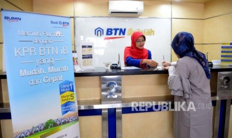 Petugas melayani transaksi nasabah di kantor layanan BTN Syariah, Jakarta, Senin (1/10).