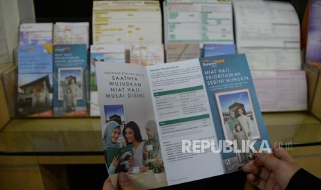 Anggota Pengawas BPKH: Rp 70 T Dana Haji di Bank Syariah. Nasabah membaca brosur tabungan rencana haji di salah satu kantor bank.