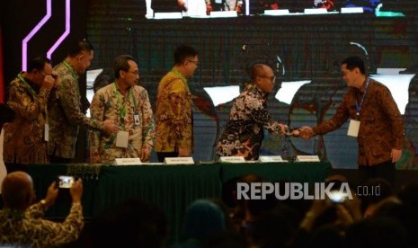 Direktur Utama BPJS Ketenagakerjaan Agus Susanto (dua kanan) bersalaman dengan Direktur Eksekutif KNKS Ventje Rahardjo  menandatangani nota kesepahaman bersama disela acara peluncuran masterplan ekonomi syariah Indonesia 2019-2024 di Jakarta, Selasa (14/5).