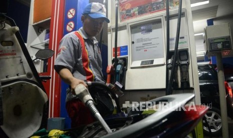 Petugas membantu konsumen mengisi Bahan Bakar Minyak (BBM) jenis pertalite pada kendaraan di SPBU Yos Sudarso, Jakarta, Ahad (25/3).