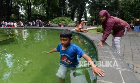 Anak-anak bermain air di air mancur di Taman Suropati, Menteng, Jakarta, Ahad (16/12).