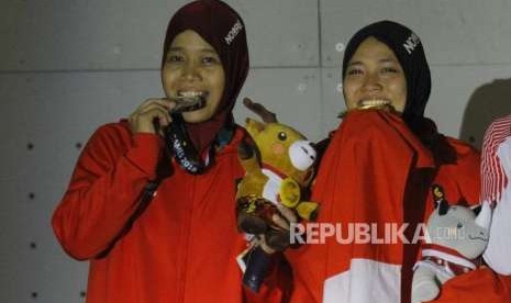 Emas Dari Panjat Dinding. Pemanjat Dinding Indonesia Aries Susanti Rahayu (kanan) dan Puji Lestari saat upacara pengalungan medali pada cabang panjat dinding nomor kecepatan putri Asian Games 2018 di Komplek Olahraga Jakabaring, Kamis (23/8) malam.