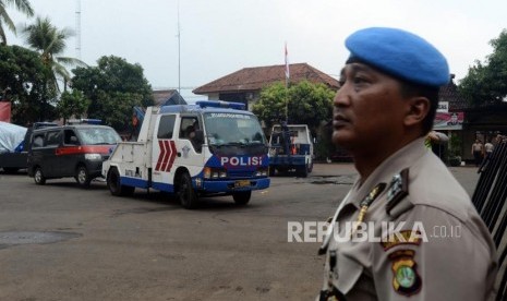 Sejumlah petugas kepolisian mengevakuasi mobil yang hancur pasca peristiwa perusakan dan pembakaran di gedung Polsek Ciracas, Jakarta, Rabu (12/12).