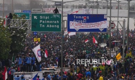 BLOKIR TOL . Mahasiswa memblokade jalan tol dalam kota sesaat sebelum aksi di depan Kompleks Gedung Parlemen RI berakhir dengan bentrok, Selasa (24/9).